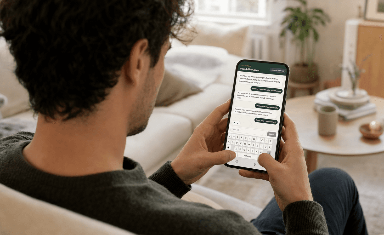 En ung man gör en felanmälan genom att chatta med BoendeFlows AI-agent i mobilen.